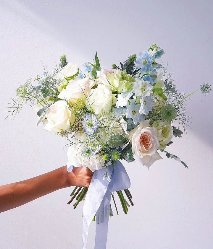 Bijelo-plavi bridal buket s delfinijem i ružama · Inzira Atelier
